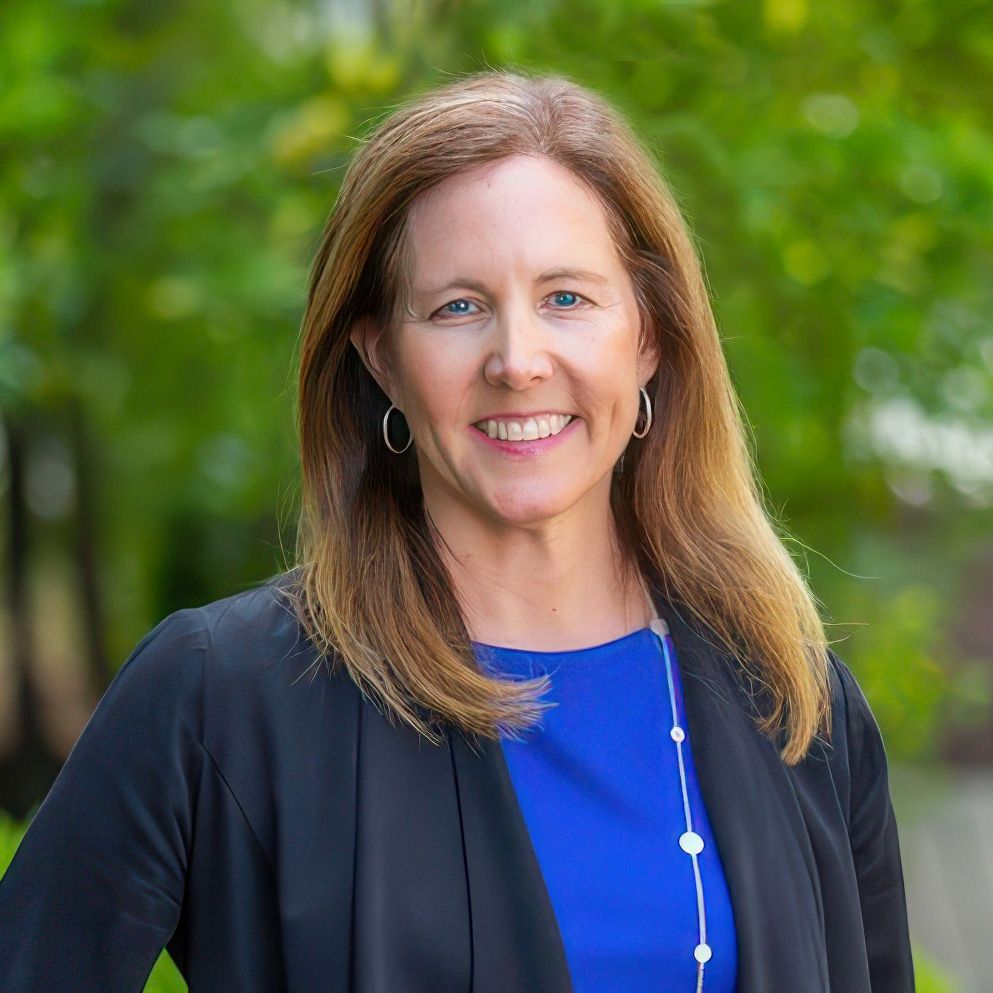 diane russell standing against a background of greenery.